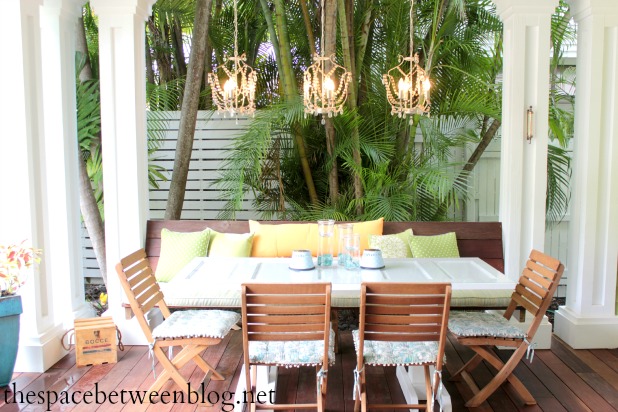 porch dining area with romantic chandeliers